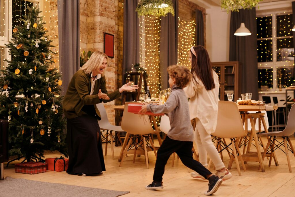 Joyful family celebrating Christmas with gift exchange indoors.